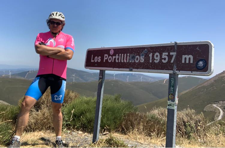 Fotografía del cicloturista aficionado en el alto de Los Portinillos (1957msm), al fondo molinos de viento y El Cierzo