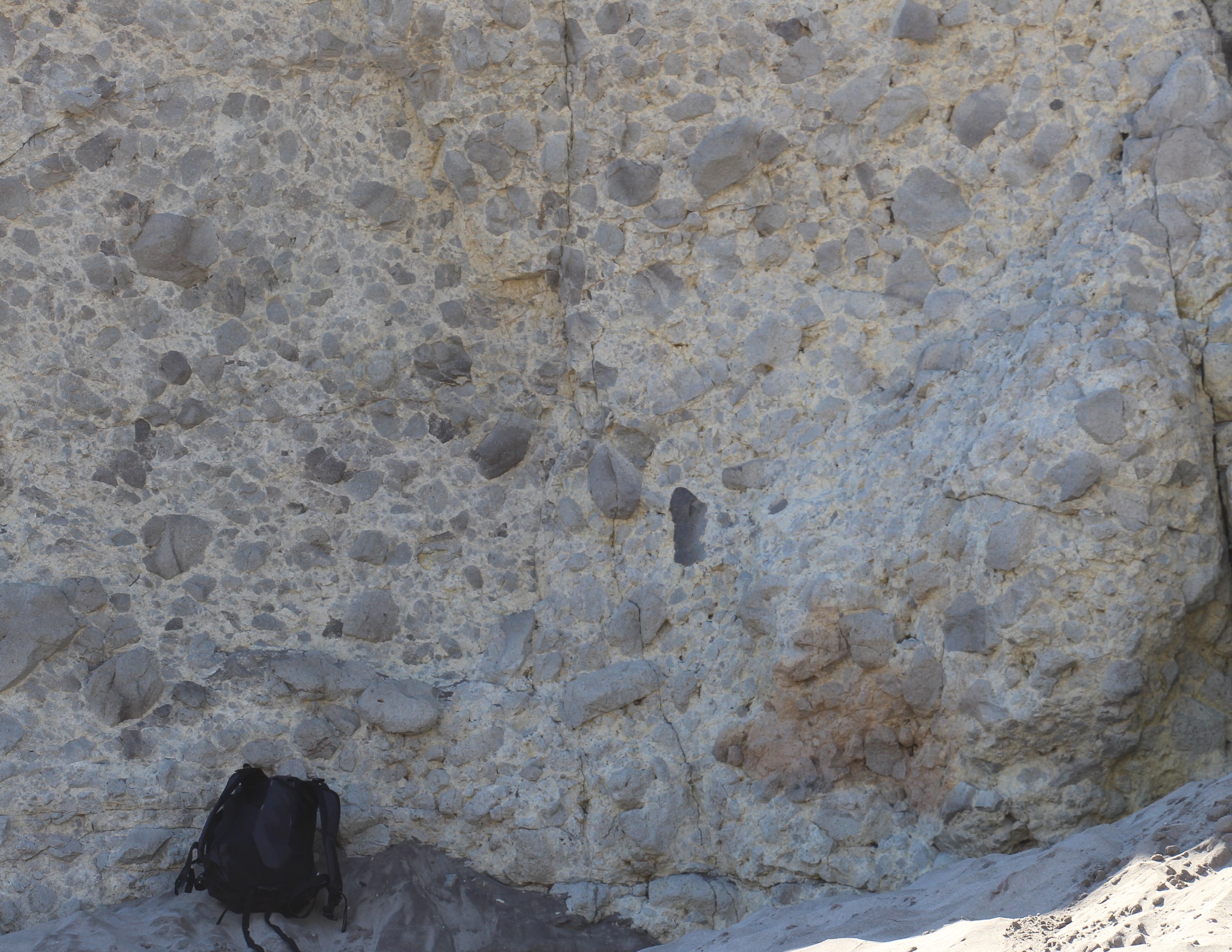Aglomerado Volcánico. Fragmentos de roca volcánica de carácter andesítico, con tamaños entre 1 y 60 cm, incluidos homogéneamente en una masa fina de fondo (tamaño ceniza) de color más claro. Playa de Mónsul. Parque Natural de Cabo de Gata – Níjar (Almería). Fotografía de campo.