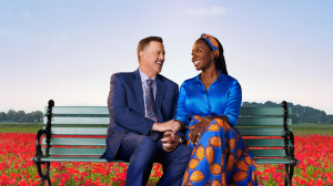 Bob and Abishola seated holding hands